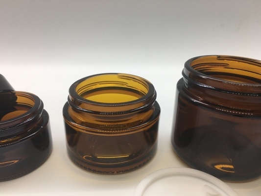 La ricarica cosmetica trasparente Amber Glass Jar Straight Round modella con il coperchio nero di plastica